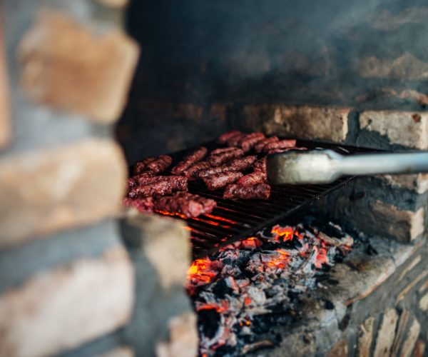 Barbecue on stone grill fireplace outdoors. Close-up.